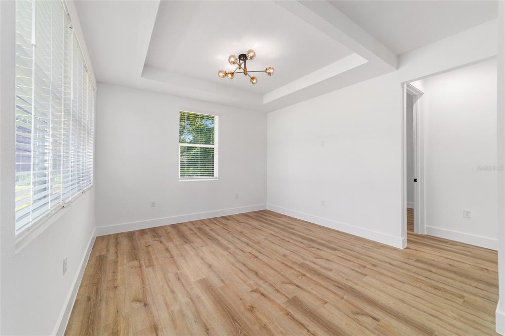 7 Oak Trail Ocala, FL 34472 - Photo 15 of 73 an empty room with wooden floor chandelier fan and windows