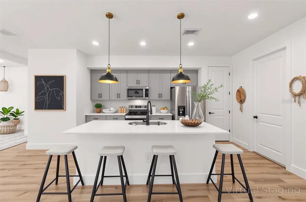 7 Oak Trail Ocala, FL 34472 - Photo 26 of 73 a kitchen with stainless steel appliances kitchen island granite countertop a stove a sink and a dining table with wooden floor