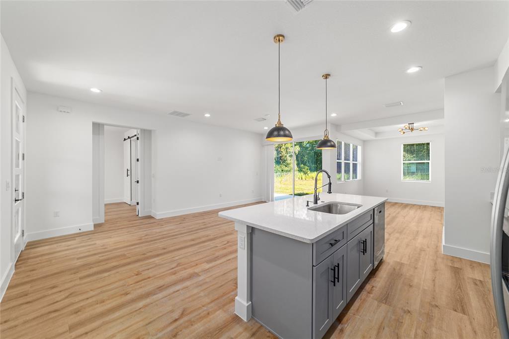 7 Oak Trail Ocala, FL 34472 - Photo 29 of 73 a room with kitchen island a sink wooden floor and a chandelier