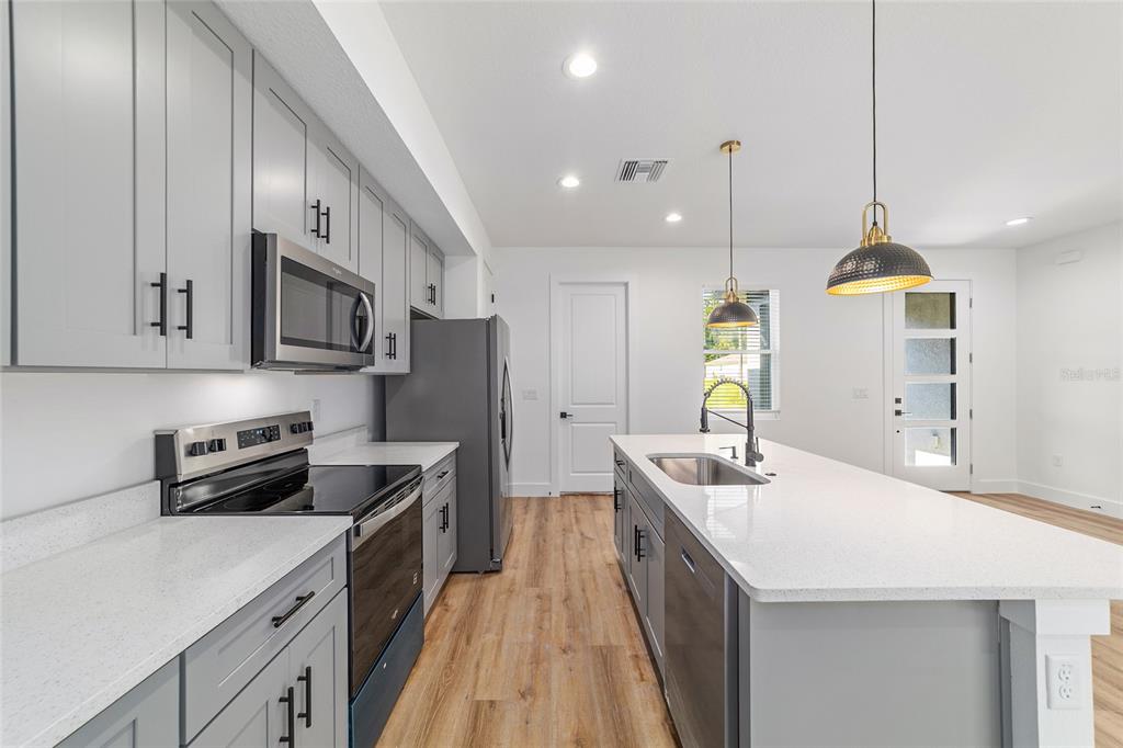 7 Oak Trail Ocala, FL 34472 - Photo 31 of 73 a kitchen with stainless steel appliances kitchen island granite countertop a sink and a refrigerator