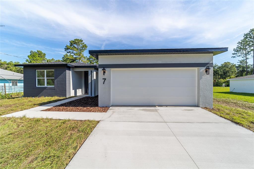 7 Oak Trail Ocala, FL 34472 - Photo 4 of 73 a front view of a house with a yard and garage