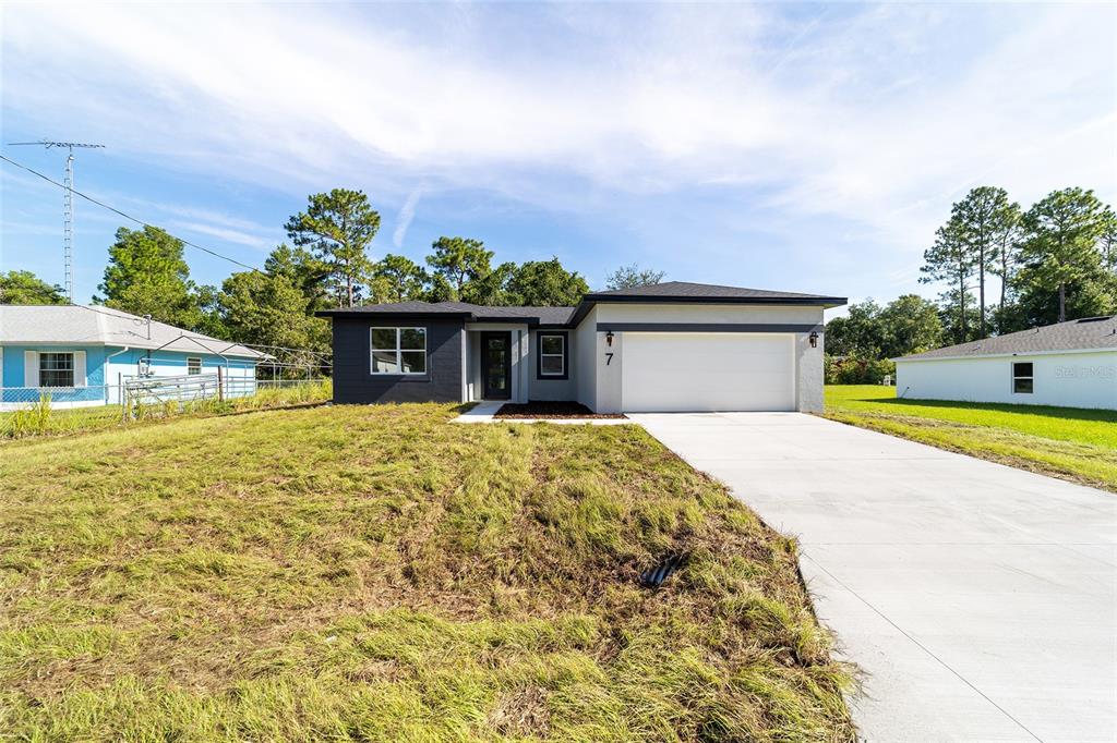 7 Oak Trail Ocala, FL 34472 - Photo 5 of 73 a front view of a house with a garden and yard