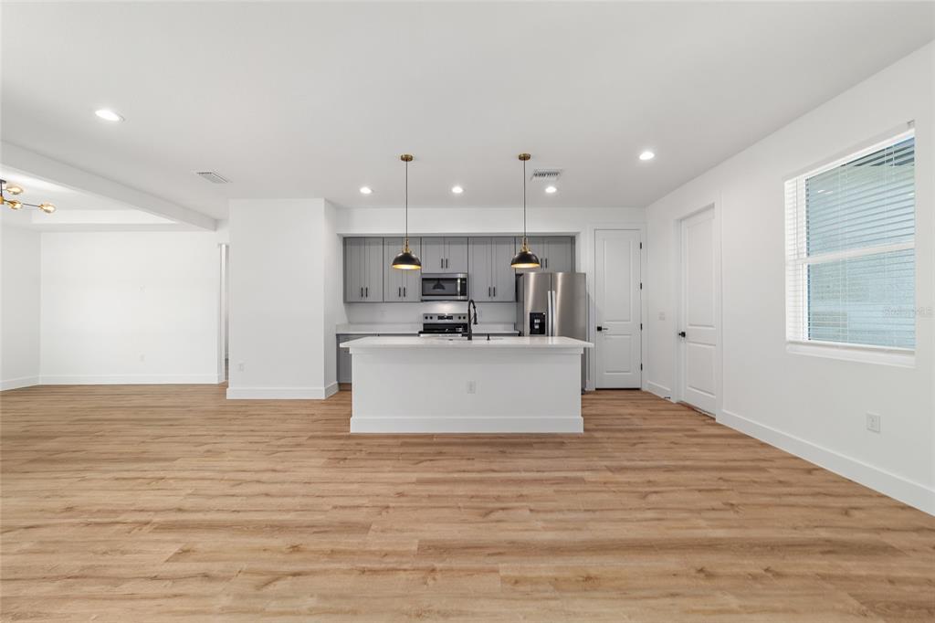 7 Oak Trail Ocala, FL 34472 - Photo 9 of 73 a view of kitchen with stainless steel appliances granite countertop a stove top oven a sink and white cabinets with wooden floor