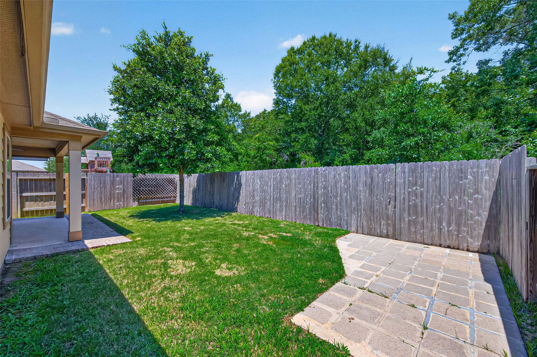 2754 Cayden Creek Way Conroe, TX 77304 - Photo 35 of 40 a view of a backyard with a swing plants and large tree