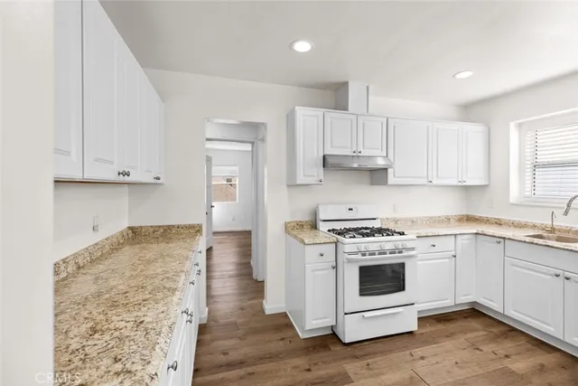 a kitchen with stainless steel appliances granite countertop a stove a sink and a refrigerator