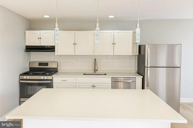 a kitchen with a stove a refrigerator and a sink