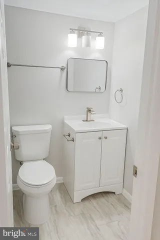 a bathroom with a toilet a sink and mirror