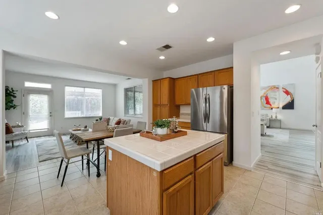 a kitchen that has a lot of cabinets a sink and a refrigerator in it