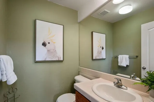 a bathroom with a sink mirror and toilet