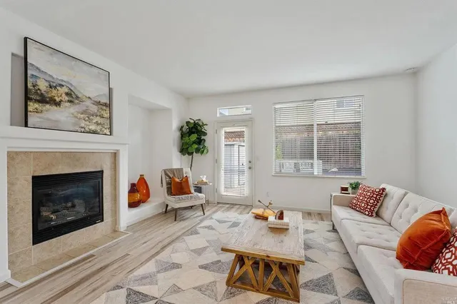 a living room with furniture a fireplace and windows