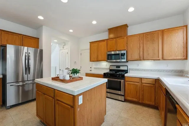 a kitchen with stainless steel appliances granite countertop a stove refrigerator sink and microwave