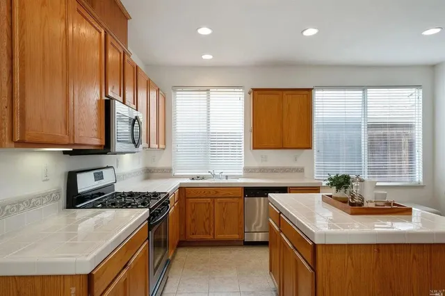 a kitchen with stainless steel appliances granite countertop a sink stove and cabinets