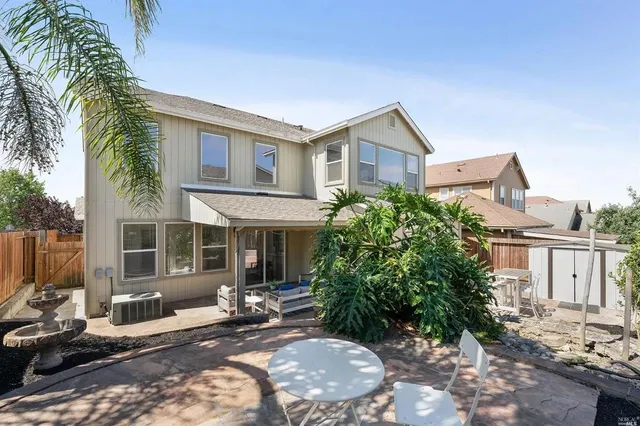 a view of a house with backyard and sitting area