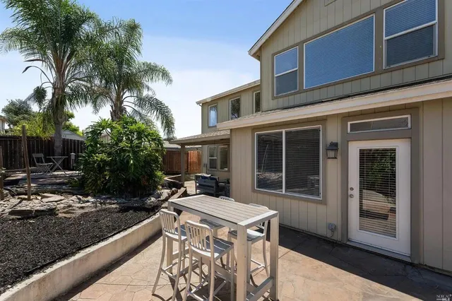 a view of a house with backyard and sitting area