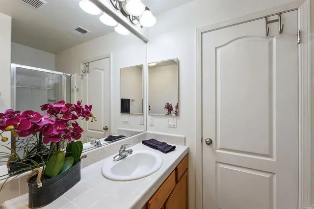 a bathroom with a sink vanity tub and shower
