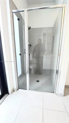 a bathroom with a shower and a glass door