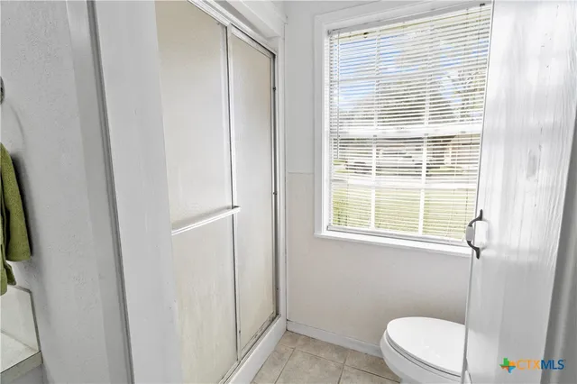 a white toilet sitting next to a bathroom sink and a window