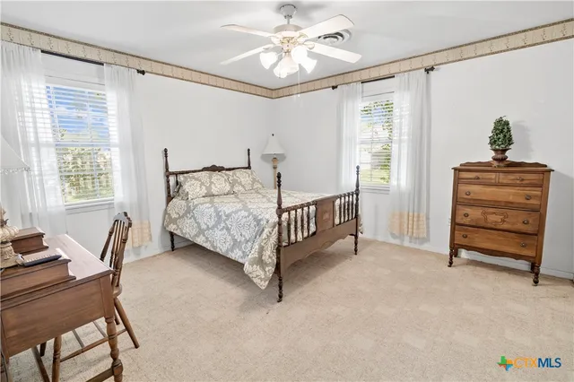 a bedroom with a bed a chandelier and a window