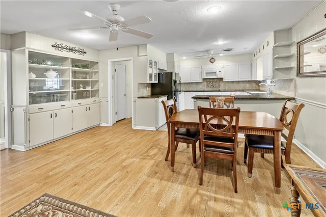 a kitchen with stainless steel appliances kitchen island granite countertop a dining table chairs and view living room