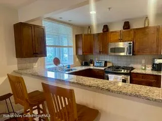 a kitchen with stainless steel appliances granite countertop a sink stove and microwave