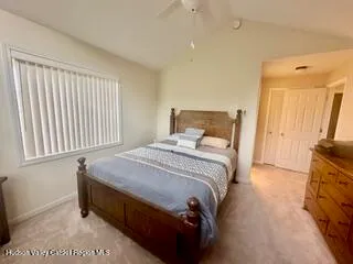 a bedroom with a bed and a flat tv screen on a dresser