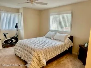 a bedroom with a bed a window and a chandelier