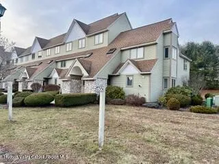 a view of a house with a yard and potted plants