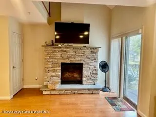 a living room with a fireplace a flat screen tv and a window