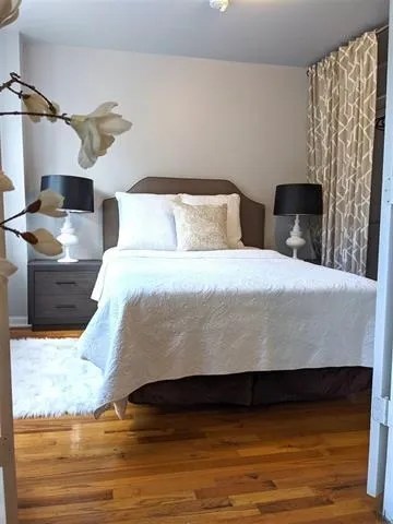 a bedroom with a bed and wooden floor