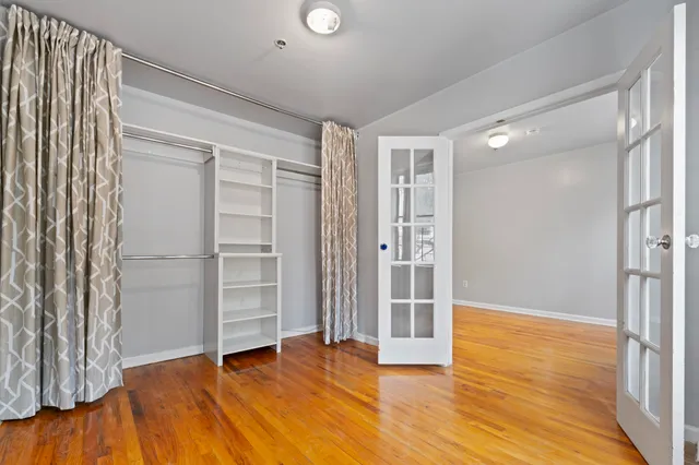 an empty room with wooden floor and closet