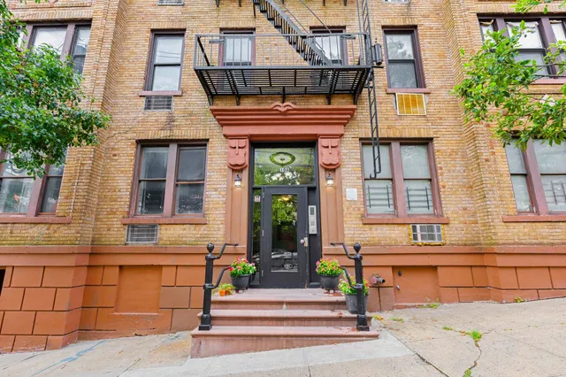 a front view of a building with a garden