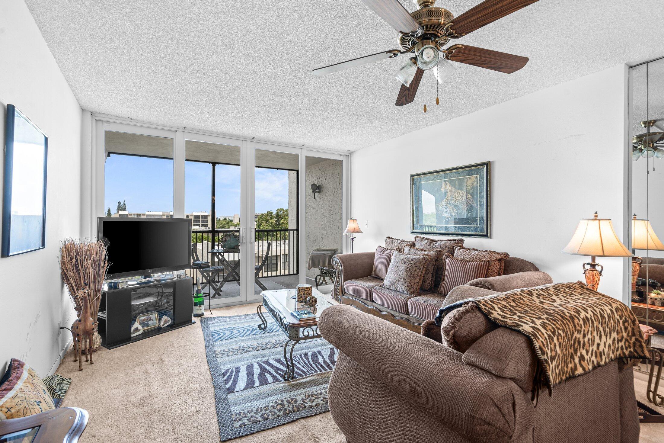 17 Royal Palm Way, Unit 504 Boca Raton, FL 33432 - Photo 13 of 44 a living room with furniture a flat screen tv and a window