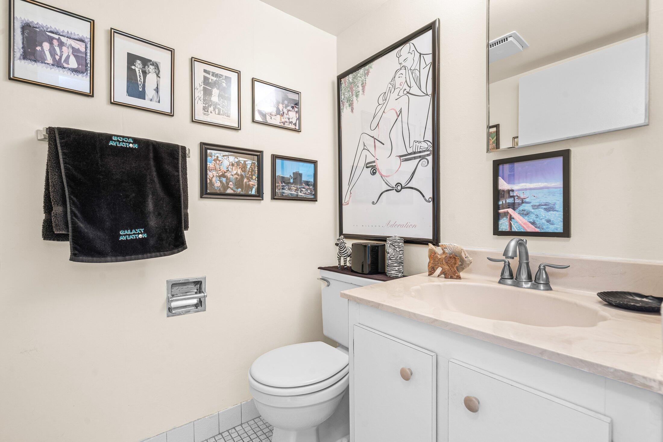 17 Royal Palm Way, Unit 504 Boca Raton, FL 33432 - Photo 18 of 44 a bathroom with a toilet a sink and a mirror