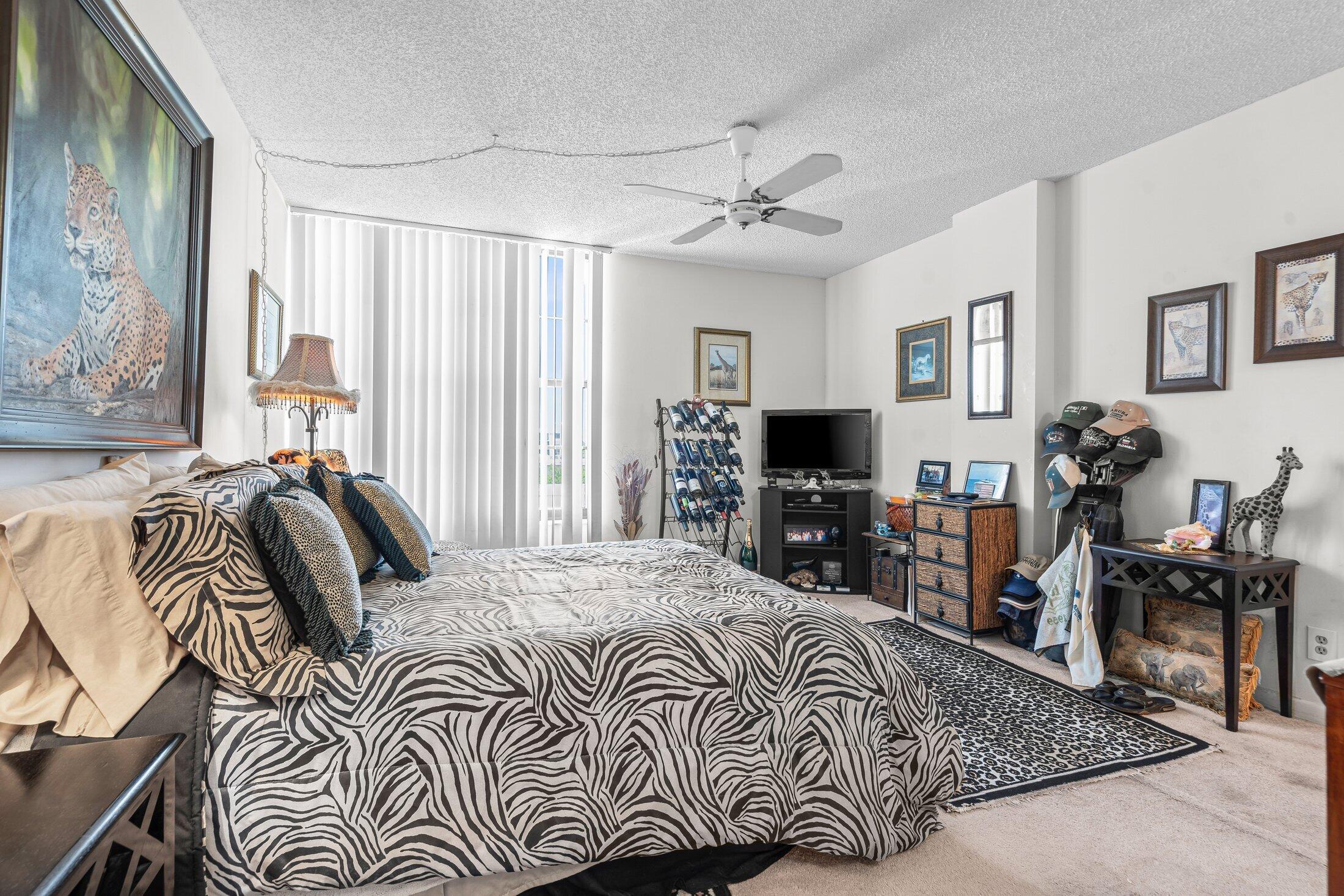 17 Royal Palm Way, Unit 504 Boca Raton, FL 33432 - Photo 19 of 44 a bedroom with a bed and a chandelier