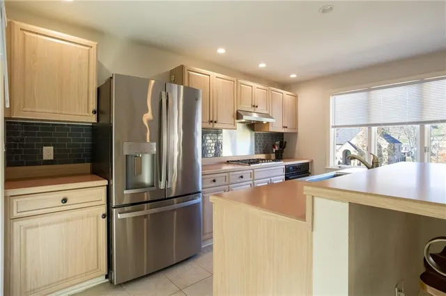 a kitchen with stainless steel appliances white cabinets and a stove top oven