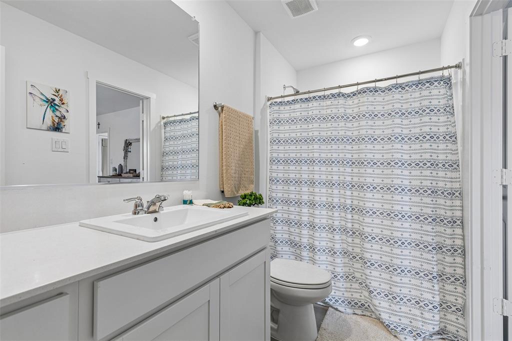 14163 Kempt Drive Pilot Point, TX 76258 - Photo 15 of 29 The private primary bathroom offers a clean, modern design with a spacious vanity, ample counter space, and a tub-shower combination. Thoughtfully positioned just off the primary suite, this well-appointed bath provides both comfort and convenience for everyday living.