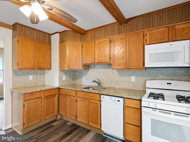 a kitchen with stainless steel appliances granite countertop a sink a stove and cabinets
