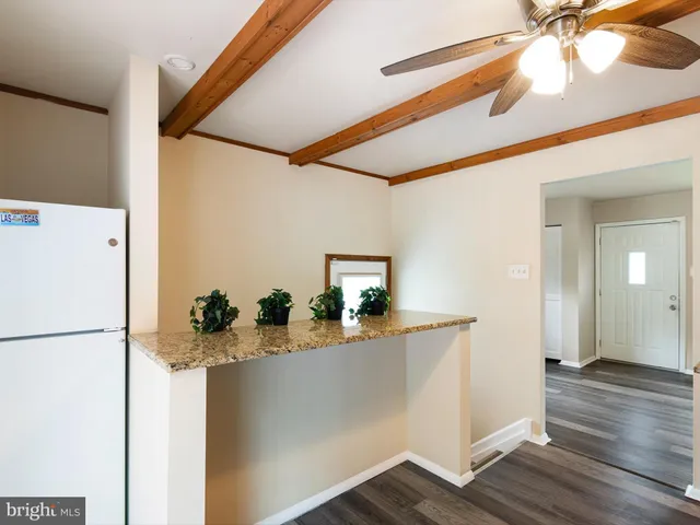 a room with a refrigerator and a wooden floor