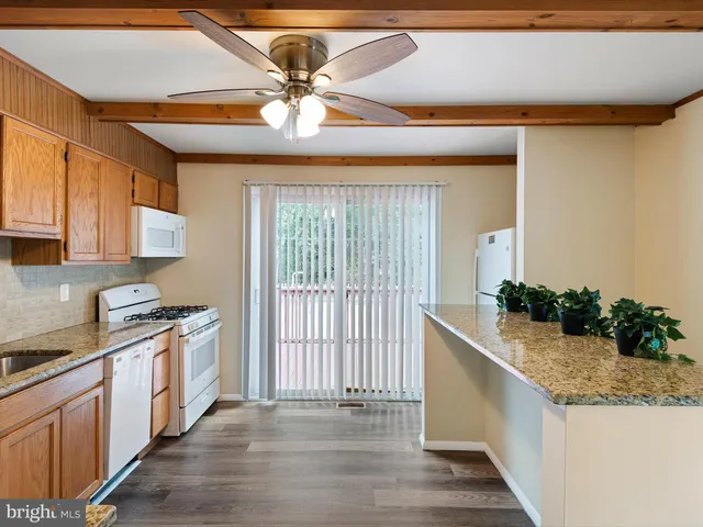 a kitchen with stainless steel appliances granite countertop a sink a stove top oven a counter space and cabinets