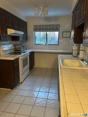 a kitchen with stainless steel appliances a stove a sink a microwave and cabinets