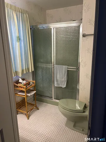 a bathroom with a toilet and a shower