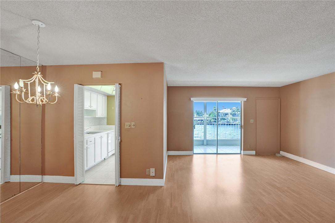 801 North Riverside Drive, Unit 7B Pompano Beach, FL 33062 - Photo 14 of 26 a view of a livingroom with wooden floor and a chandelier
