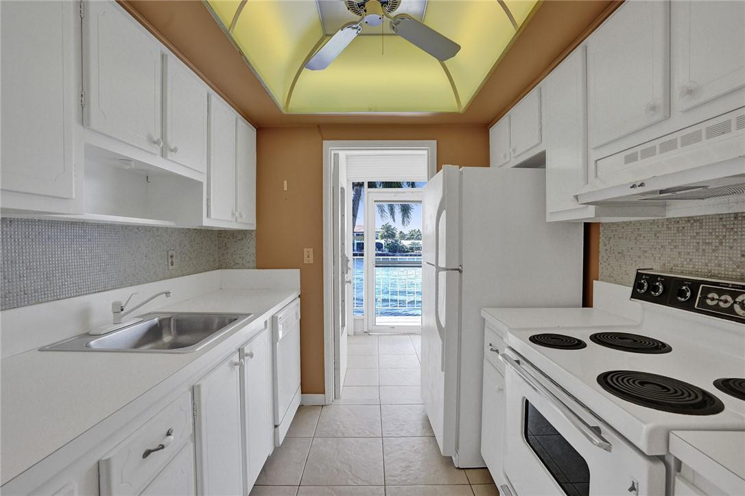 801 North Riverside Drive, Unit 7B Pompano Beach, FL 33062 - Photo 17 of 26 a kitchen with a sink a stove and cabinets