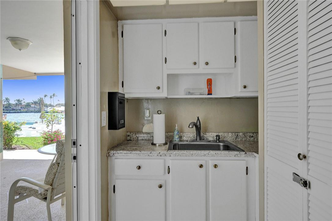 801 North Riverside Drive, Unit 7B Pompano Beach, FL 33062 - Photo 24 of 26 a kitchen with granite countertop white cabinets and stainless steel appliances