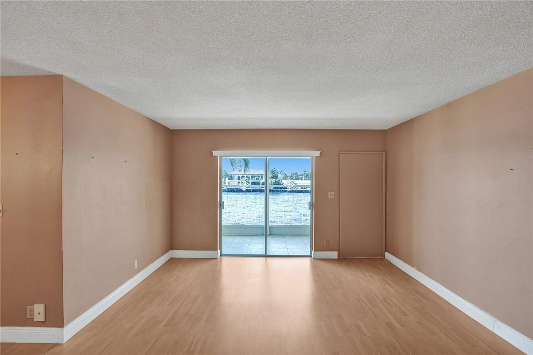 801 North Riverside Drive, Unit 7B Pompano Beach, FL 33062 - Photo 5 of 26 an empty room with wooden floor and windows