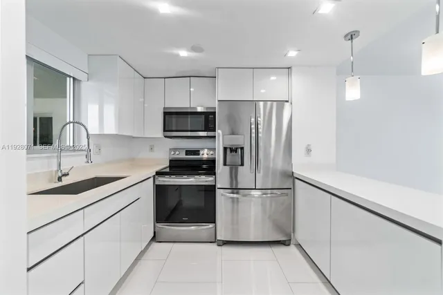 a kitchen with stainless steel appliances a refrigerator sink and microwave