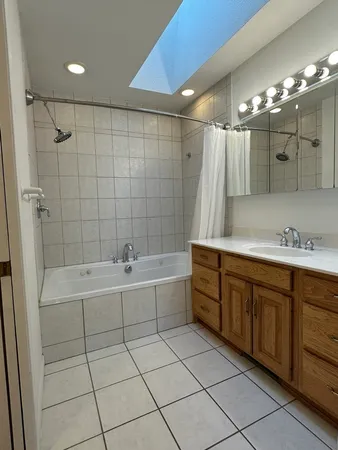 a spacious bathroom with a mirror a sink and bathtub