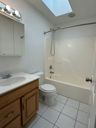 a bathroom with a granite countertop sink a toilet and shower