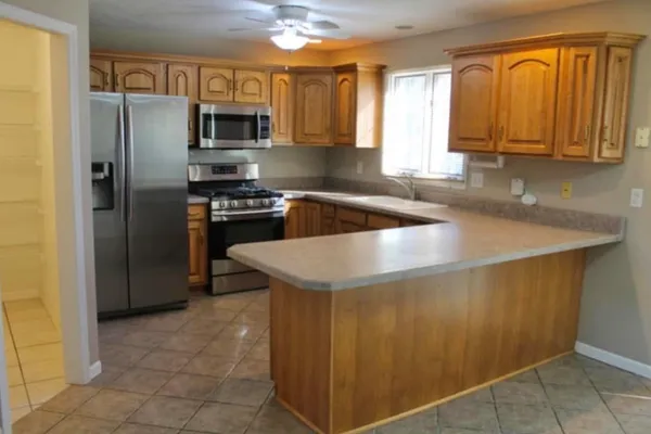 a kitchen with stainless steel appliances granite countertop a refrigerator and a sink