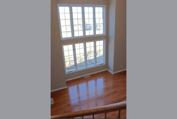 a view of a hallway with wooden floor and a window
